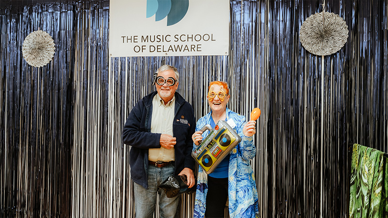 Flute faculty member Margaret Swinchoski and friend at the photo booth at the Milford Branch