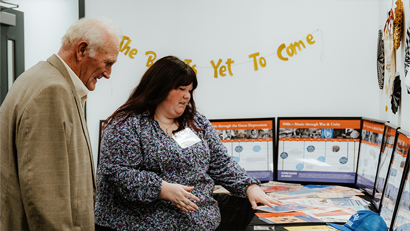 Director of Community and Operations Mary Jane Vanvestraut with Senator Dave Wilson, looking over the decades room at the Milford Branch