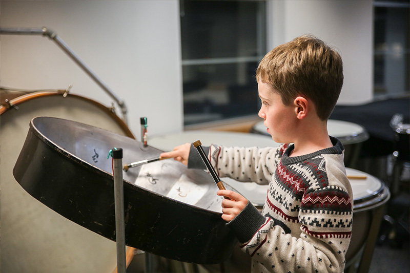 A visitor plays one of the exotic instruments in the Scavenger Hunt