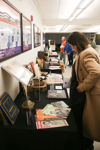 Delaware Symphony Orchestra Music Director Michelle Di Russo browses the decades themed room at the Wilmington Branch showcasing 100 years of music excellence