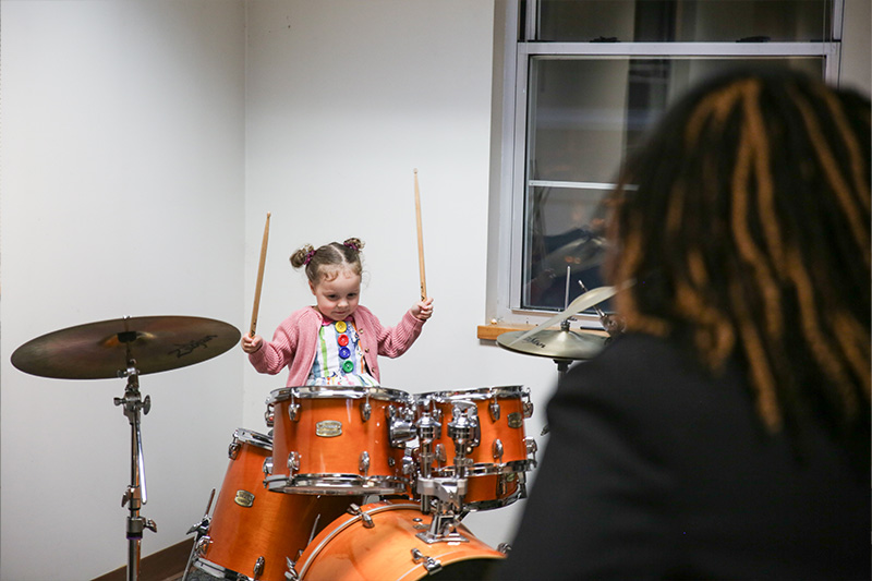 A young percussionist enjoys the drum petting zoo
